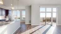 Located at 5909 Sharpsburg Dr in Madison, Wisconsin, this single-floor residence offers a thoughtfully designed open-concept layout filled with natural light. Large windows throughout the living and dining areas frame sweeping outdoor views of the surrounding landscape, while light-toned hardwood flooring ties the space together seamlessly.

The kitchen is a standout feature, showcasing rich dark cabinetry, granite countertops with subtle veining, a classic white subway tile backsplash, and a full suite of stainless steel appliances including a refrigerator, range, and built-in microwave. A spacious central island with a stainless steel sink and elegant pendant lighting above serves as both a functional workspace and a natural gathering point. The kitchen opens directly to the living area, which benefits from an abundance of sunlight streaming through floor-to-ceiling sliding glass doors that lead to a private outdoor deck.

The bathroom is well-appointed with a granite-topped double vanity, dark cabinetry matching the kitchen, and a walk-in shower. A dedicated closet with built-in shelving and carpeted flooring provides generous storage. The overall design is clean, contemporary, and cohesive, making this a well-equipped and comfortable residence in Madison.