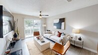 Located at 50 Stone Mill Dr SE in Cartersville, Georgia, this single-story residence offers a thoughtfully designed floor plan encompassing one bedroom, two full bathrooms, a dedicated office, and an in-unit laundry room. The open-concept living and dining area is bright and welcoming, featuring light wood-style flooring, neutral warm-toned walls, a textured ceiling, and a ceiling fan. Sliding glass doors flood the living room with natural light and provide access to an outdoor area with views of the surrounding greenery. The dining space flows seamlessly into the kitchen, which is equipped with white shaker-style cabinetry, a classic subway tile backsplash, white quartz countertops, and stainless steel appliances. The generously sized primary bedroom features plush carpeting, a ceiling fan, a wide window for natural light, and a walk-in closet with built-in shelving. Both bathrooms are finished with light wood-look flooring, white vanities with quartz countertops, and large mirrors. The dedicated laundry room houses a full-size side-by-side washer and dryer with overhead wire shelving. The office provides a versatile additional space, completing this functional and well-finished home.