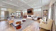 Located at 243 Steele Rd in West Hartford, CT, this sophisticated single-floor lounge space offers a refined and welcoming atmosphere defined by high-end architectural details and thoughtful design. The centerpiece of the room is a striking coffered ceiling with recessed lighting, which adds depth and a sense of grandeur to the open layout. Underfoot, richly patterned herringbone hardwood flooring anchors the space with warmth and texture.

A sleek, wall-mounted linear fireplace framed in warm wood paneling serves as a dramatic focal point, complemented by a wall-mounted flat-screen television above. Generous seating arrangements, including a large sectional sofa and accent chairs, are thoughtfully positioned to encourage conversation and relaxation.

Abundant natural light streams in through multiple sets of French doors and transom windows, connecting the interior to the outdoors and creating an airy, open ambiance. A built-in kitchenette area with warm wood cabinetry, a beverage refrigerator, and a Keurig station adds everyday convenience. Geometric-patterned hardwood flooring in the kitchenette nook further highlights the space's attention to detail. The overall aesthetic blends classic architectural elements with contemporary furnishings for a polished, community-centered environment.