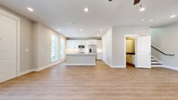 This well-appointed two-story home offers 2 bedrooms and 3 bathrooms across two thoughtfully designed floors of comparable size. The main level centers around a bright, open-concept kitchen and living area finished with light hardwood flooring and recessed lighting. The kitchen is equipped with stainless steel appliances—including a French door refrigerator, range, microwave, and dishwasher—complemented by white shaker cabinetry with black hardware, a herringbone tile backsplash, and a central island. Ceiling fans enhance comfort throughout, and large windows invite abundant natural light. A dedicated entry area with hardwood floors and a windowed door provides a welcoming arrival. The upper level hosts both bedrooms, each featuring plush carpeting, tall ceilings, and dual arched windows that frame outdoor views. The primary bedroom is a generous retreat with ample space. The three bathrooms are finished in clean, contemporary styles—one featuring a glass-enclosed walk-in shower with subway tile and a built-in niche, and another offering a soaking tub with tiled surround. A closet, hallway, and dual staircases round out a practical and cohesive floor plan.