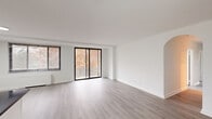 Located at 4921 Seminary Rd in Alexandria, Virginia, this well-appointed residence offers four bedrooms and two bathrooms across a single thoughtfully designed floor. The open living room is bright and airy, featuring light gray hardwood-style flooring, crisp white walls, and a large sliding glass door that opens to a private balcony with outdoor views — allowing natural light to pour in throughout the day. A secondary window further enhances the sense of openness in this generous main living area.

The kitchen is efficiently designed with a galley layout, showcasing white shaker-style cabinetry, dark granite countertops, stainless steel appliances including a gas range and built-in microwave, and the added convenience of an in-unit washer and dryer. The bedrooms are well-sized, with the spacious primary bedroom offering ample room to accommodate a full suite of furniture. Bedrooms feature large closets with built-in shelving and hanging rods, and windows with views of the surrounding greenery.

The two bathrooms are finished with white tile, dark granite vanity tops, undermount sinks, chrome fixtures, and backlit LED mirrors, lending a clean, modern aesthetic. Throughout the residence, consistent light-toned flooring and a neutral color palette create a cohesive, contemporary atmosphere.