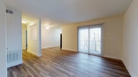 Located at 495 Nutt Rd in Phoenixville, Pennsylvania, this single-floor residence offers a clean, modern aesthetic with thoughtful design details throughout. The open living area is a standout feature, showcasing wide-plank hardwood-style flooring that extends seamlessly through the space, creating a cohesive and polished look. Neutral, warm-toned walls complement the light-filled interior, contributing to a bright and welcoming ambiance. A ceiling fan is positioned centrally in the living area, providing both functionality and a finished look to the ceiling. Large sliding glass doors dressed with vertical blinds flood the space with natural light and provide direct access to an outdoor area, framing views of the surrounding greenery. The open layout between the living and adjacent areas allows for flexible furniture arrangements and a natural flow throughout the home. Crisp white baseboards and trim add a clean architectural contrast to the flooring and walls. This single-level layout offers convenient, step-free living throughout the entire residence, making the space highly accessible and easy to navigate.
