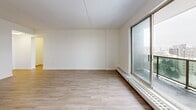 This well-appointed 2-bedroom, 1-bathroom unit at 1001 Talwood Dr in Peterborough, Ontario offers a bright and functional layout finished with light wood laminate flooring and clean white walls throughout. The open-concept living and dining area is generously sized, filled with natural light from large sliding glass doors that lead out to a private balcony with sweeping city views. The kitchen is thoughtfully designed with white cabinetry, a classic white subway tile backsplash, stainless steel appliances including a range and over-the-range microwave, and a built-in sink — opening directly into the dining area for easy flow. Both bedrooms are comfortably proportioned, featuring large windows that bring in ample natural light and views of the surrounding cityscape. The primary bedroom includes a sliding door closet for convenient storage. The bathroom is finished with crisp white subway tile surrounding the bathtub and shower, complemented by a clean white vanity and toilet. A dedicated hallway connects all rooms, providing a practical and organized layout. Baseboard heating is present throughout the unit, ensuring year-round comfort. The overall ambiance is clean, modern, and move-in ready.