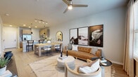 Located at 6850 Foxtail Palm Way in Bradenton, Florida, this single-floor residence offers a thoughtfully designed open-concept layout with modern finishes throughout. The kitchen is a standout feature, showcasing light wood cabinetry, white quartz countertops, a classic subway tile backsplash, and a full suite of stainless steel appliances including a range, microwave, and dishwasher. A peninsula with bar seating and pendant lighting makes it ideal for both cooking and casual dining. The kitchen flows seamlessly into the dining and living areas, where wide-plank luxury vinyl flooring, a ceiling fan, and large windows with blinds and drape panels create a bright, airy atmosphere. The living room offers generous space for entertaining, accented by track lighting and tasteful wall art. The bedroom is a serene retreat featuring plush carpeting, a tray ceiling, a ceiling fan, and floor-to-ceiling window treatments that filter soft natural light. The bathroom is finished with light wood vanity cabinetry, quartz countertops, an illuminated mirror, and coordinating luxury vinyl flooring. Throughout the residence, the design maintains a cohesive contemporary aesthetic with warm neutral tones, clean lines, and quality materials that reflect the relaxed Florida lifestyle.