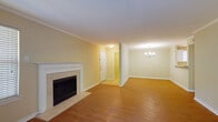 This single-floor, three-bedroom home offers a well-organized layout with a blend of practical finishes and comfortable living spaces throughout. The open living and dining area serves as the heart of the home, featuring warm hardwood flooring, crown molding, and a classic white-mantled fireplace with tile surround. An elegant chandelier highlights the dining area, while the living space flows naturally toward the entryway. A sliding glass door leads to an outdoor balcony, filling the adjacent room with natural light and providing views of surrounding greenery. The kitchen is efficiently designed in a U-shape, outfitted with white cabinetry offering generous storage, light countertops, a double stainless steel sink, and white appliances including an electric range and built-in microwave. Light tile flooring keeps the kitchen bright and easy to maintain. Each of the three bedrooms is carpeted and features a ceiling fan with light fixture and a window with blinds for natural light and privacy. The rooms are well-proportioned, offering comfortable and versatile living spaces. The bathroom includes tile flooring, a vanity with storage, a large mirror, and grab bars for added accessibility. Overall, the home presents a clean, functional, and welcoming environment.