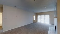 Located in Dallas, Texas, this single-story space offers a clean and functional layout designed for comfortable everyday living. The main living area is generously proportioned, featuring plush wall-to-wall carpeting that adds warmth underfoot. A textured ceiling with recessed lighting provides a neutral overhead finish, while HVAC vents are thoughtfully integrated throughout. Large sliding glass doors dressed with vertical blinds allow an abundance of natural light to flood the space and offer a direct view to the outdoors. The neutral, light-toned walls create a bright and versatile backdrop, making the space easy to furnish and personalize. A doorway visible from the main living area leads to an adjacent room, hinting at a connected and practical floor plan. The overall ambiance is open, airy, and move-in ready, with a straightforward design that prioritizes livability. The single-floor layout ensures easy accessibility and seamless flow throughout, making it a practical and welcoming environment in the heart of Dallas.