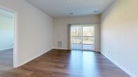 This well-appointed one-bedroom, one-bathroom unit on S Adams Street in Oswego, Illinois offers a thoughtfully designed single-floor layout. The open-concept kitchen and living area serves as the heart of the unit, featuring rich dark-espresso cabinetry with ample upper and lower storage, light quartz countertops, a stainless steel appliance suite including a gas range, dishwasher, microwave, and refrigerator, and recessed lighting overhead. The kitchen flows seamlessly into the living area, which is finished with warm hardwood-style flooring and sliding glass doors that open onto a private balcony with outdoor views — filling the space with natural light. The bedroom is a comfortable, well-proportioned room with its own window overlooking greenery, hardwood-style flooring, and access to a dedicated closet. The bathroom is clean and functional, featuring a dark-cabinet vanity with a quartz countertop, a large mirror, and a towel bar. Throughout the unit, neutral walls, clean white trim, and consistent hardwood-style flooring create a cohesive, modern aesthetic. A dedicated closet provides additional storage convenience for residents.