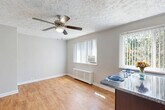 Located at 30 Crescent Rd in Greenbelt, Maryland, this one-bedroom, one-bathroom residence offers a well-organized single-floor layout designed to maximize every square foot. The open-concept living, dining, and kitchen area forms the heart of the home, featuring warm hardwood-style flooring, a textured ceiling, and a ceiling fan with light fixture. Multiple windows dressed with vertical blinds allow natural light to fill the space while providing views of the surrounding greenery. A radiator heating unit and wall-mounted air conditioner ensure year-round comfort.

The kitchen is a standout feature, equipped with dark espresso cabinetry, granite-style countertops, stainless steel appliances including a gas range and refrigerator, and a peninsula that doubles as a dining surface — ideal for casual meals or additional prep space.

The bedroom is a comfortable retreat finished with plush carpet flooring, a ceiling fan, crown molding, a radiator, and a window that invites natural light. The room also includes closet access, and the unit as a whole offers four closets, providing generous storage throughout.

The bathroom features a full soaking tub with a handheld showerhead, white subway tile surround, and a window for natural ventilation. A dedicated entrance completes this thoughtfully laid-out Greenbelt residence.