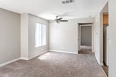 Located at 1313 W Memory Ln in Santa Ana, California, this single-story residence offers a practical and comfortable layout throughout. The living area is generously sized, finished with neutral-toned carpet and anchored by a ceiling fan with light kit. Textured ceilings and vertical blind-covered windows are consistent throughout, allowing natural light to filter in while maintaining privacy. The space flows openly toward the kitchen, which features warm wood-toned cabinetry, white countertops, a stainless steel double-basin sink, a white range, and durable wood-look vinyl flooring. A window with vertical blinds brings in additional daylight to the kitchen area. The bedrooms are carpeted and well-proportioned, each offering ceiling fans and windows. One bedroom features large sliding-door closets that provide ample storage, while another includes a sliding glass door with an outdoor view. The bathroom is clean and functional, featuring a tub/shower combination with a curtain, a white vanity with cabinetry above, a countertop sink, and wood-look vinyl flooring. Additional storage cabinetry in the bathroom adds practicality. Overall, the residence presents a clean, move-in-ready interior in a convenient Santa Ana location.