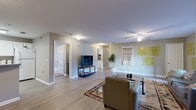 This well-appointed single-floor residence offers four bedrooms and four bathrooms, thoughtfully designed to maximize functionality and comfort. The open living room serves as the heart of the home, featuring light wood-style flooring, a ceiling fan, and ample space for seating and entertainment. Large windows invite natural light, creating a bright and welcoming atmosphere throughout.

The kitchen is outfitted with white cabinetry, generous countertop space, and a full suite of appliances including an electric range, dishwasher, and over-the-range microwave — well-suited for everyday cooking and shared living.

Each of the four bedrooms is a private suite with its own bathroom, offering independence and convenience. The bedrooms feature plush carpeting and individual in-room amenities, including a dedicated workspace area, mini-refrigerator, and microwave in select rooms — ideal for student or professional living. Closets with built-in shelving provide practical storage solutions.

Three hallways connect the layout efficiently, ensuring smooth flow between spaces. The bathrooms are clean and functional, each featuring a tub-shower combination. Throughout the residence, a neutral color palette of soft grays and whites creates a calm, cohesive aesthetic that is both modern and livable.