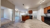 Located at 8525 Hidden River Pkwy in Tampa, Florida, this single-story home offers four bedrooms and two full bathrooms across a generous, thoughtfully designed floor plan. The open-concept living and kitchen area serves as the heart of the home, where light-toned wood-look flooring flows seamlessly throughout. The kitchen is outfitted with rich cherry wood cabinetry, granite countertops, a peninsula with an undermount sink, and black and stainless steel appliances including a refrigerator, range, microwave, and dishwasher. Track lighting illuminates the space, while the adjacent living room benefits from natural light through large windows fitted with blinds and a ceiling fan overhead. The spacious primary bedroom features plush carpeting and connects to an en-suite bathroom equipped with a granite-topped vanity, a glass-enclosed tub/shower combo, and wood-look flooring. A second full bathroom mirrors the same quality finishes, including a granite vanity and a glass-enclosed walk-in shower. The three additional bedrooms are carpeted and receive ample natural light. A dedicated laundry room houses a full-size washer and dryer with built-in overhead shelving for added storage convenience.