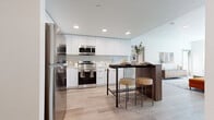 Located at The Harborside in West Sacramento, CA, this single-story, 3-bedroom, 2-bathroom home offers a thoughtfully designed open-concept layout with modern finishes throughout. Light wood-look flooring flows seamlessly across all rooms, lending warmth and continuity to the space.

The bright living room is anchored by large windows that invite abundant natural light, creating an airy, welcoming atmosphere. The contemporary kitchen features sleek white cabinetry extending to the ceiling, stainless steel appliances, a tile backsplash, recessed lighting, and a freestanding island with bar seating — ideal for casual dining and entertaining.

The primary bedroom is a comfortable retreat with a well-sized window overlooking the outdoors and access to a closet. Additional bedrooms offer similar clean, light-filled aesthetics with ample closet storage, including a walk-in configuration visible in one room.

Both bathrooms are finished in a clean, modern style with white vanity cabinetry, light countertops, and wood-look flooring. One bathroom includes a shower/tub combination, while the second provides a spacious layout with a separate shower area.

Throughout the home, crisp white walls, consistent flooring, and an understated design palette create a cohesive and functional living environment at The Harborside.