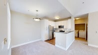 Located at 1600 Whitewood Drive in San Jose, CA, this well-appointed 2-bedroom, 2-bathroom residence offers a thoughtfully designed single-floor layout. The open-concept kitchen is a standout feature, showcasing white shaker cabinetry, dark countertops, a peninsula with breakfast bar seating, and stainless steel appliances including a refrigerator, range, and microwave. Wood-style flooring anchors the kitchen area, while plush carpet flows throughout the living spaces. The living room benefits from natural light and is accented by a stylish pendant light fixture. The primary bedroom is generously sized and features soaring vaulted ceilings, a dramatic arched window above sliding glass doors that open to a private balcony with lush tree views, flooding the space with natural light. The second bedroom is carpeted and bright, with a large window framing peaceful outdoor scenery. Both bathrooms are well-appointed with full tub-shower combinations, dark-toned countertops, white cabinetry, and wood-style flooring. A dedicated in-unit laundry room with side-by-side washer and dryer and built-in shelving adds everyday convenience. Two closets provide ample storage throughout.