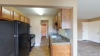 Located at 2209 Wabash Ct W in Columbus, Ohio, this single-floor unit offers a practical and comfortable layout throughout. The living area is spacious and carpeted, finished in warm neutral tones, and features large sliding glass doors that flood the room with natural light while providing direct access to an outdoor area. An additional window further enhances the bright, open feel of the space.

The kitchen is efficiently designed in a galley-style layout, featuring warm-toned wooden cabinetry both above and below the counters, dark laminate countertops, a stainless steel sink, and durable wood-look flooring. Black appliances — including a full-size refrigerator and a gas range — are included, making the kitchen fully equipped for everyday use.

The bedroom is carpeted and offers ample storage through a large sliding-door closet that spans much of one wall, complemented by a window that brings in natural light.

The bathroom is clean and functional, featuring a full-size soaking tub with a shower combination enclosed by a curved rod, wood-look tile flooring, and neutral wall tones that contribute to a fresh, understated aesthetic.

Overall, the unit presents a cohesive, move-in-ready interior with consistent neutral color palettes, practical finishes, and thoughtful storage solutions throughout.