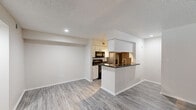 Located at 6047 S Hulen Street in Fort Worth, TX, this 2-bedroom, 3-bathroom residence offers a well-organized single-floor layout designed for functional everyday living. The open-concept living and kitchen area serves as the heart of the home, featuring durable wood-look luxury vinyl plank flooring, neutral-toned walls, and a textured ceiling. The kitchen is outfitted with white cabinetry, dark granite-style countertops, stainless steel appliances including a refrigerator and range, and a built-in microwave. A peninsula with a sink and dark countertop extends into the living area, providing additional prep space and a natural division between the two zones. Multiple windows fitted with white blinds allow natural light to fill the space. The two bedrooms are carpeted for comfort, each with a ceiling fan and window. The spacious primary bedroom includes a closet and connects conveniently to the hallway. The three bathrooms feature white tile tub-and-shower combos, dark granite-style vanity countertops, framed mirrors, and white cabinetry. A dedicated laundry area with washer hookups rounds out the practical amenities of this well-appointed Fort Worth residence.