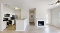 Located in Charlotte, NC, this well-appointed one-bedroom, one-bathroom residence offers a thoughtfully designed single-floor layout. The open-concept living, dining, and kitchen area forms the heart of the home, featuring light wood-style flooring, crown molding, and a ceiling fan that enhances airflow and comfort. A white-framed fireplace serves as a focal point in the living room, complemented by large windows that invite an abundance of natural light and offer pleasant outdoor views.

The kitchen is equipped with stainless steel appliances, including a refrigerator, range, and built-in microwave, alongside white cabinetry and granite countertops. A peninsula with matching granite provides additional prep and dining space. A dedicated pantry offers generous storage.

The bedroom is a comfortable retreat featuring plush carpeting, a ceiling fan, a large window, and access to multiple closets. The bathroom includes a full tub-shower combination with white tile surround and a granite-topped vanity.

Additional highlights include an in-unit laundry area and a private balcony — ideal for outdoor relaxation. Three closets throughout the unit provide ample storage. The clean, neutral palette and consistent finishes create a cohesive and inviting atmosphere throughout this Charlotte residence.