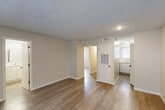 Located at 515 Gardere Ln in Baton Rouge, Louisiana, this single-story, one-bedroom, two-bathroom unit offers a well-organized layout across a compact but functional floor plan. Wood-look plank flooring runs consistently throughout, lending a cohesive and clean aesthetic to every room.

The living room provides a comfortable gathering area filled with natural light from a window overlooking the exterior, complemented by neutral-toned walls and a textured ceiling. A central hallway connects the main living areas to the bedroom and bathrooms, with multiple doors providing easy access throughout.

The kitchen is efficiently designed with white shaker-style cabinetry, marble-look countertops, a single-basin sink beneath a window, and black appliances including a full-size refrigerator and range. A dishwasher is also included.

The bedroom is a well-proportioned space featuring a ceiling fan with light fixture, a window with natural light, and direct access to a dedicated bathroom. The primary bathroom includes white cabinetry, a marble-look vanity countertop, a large mirror with vanity lighting, and a tiled tub/shower combination. A second full bathroom serves the rest of the unit. A closet provides additional storage within the layout.
