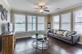 This single-story unit in Memphis, Tennessee offers a thoughtfully designed layout that maximizes both comfort and functionality. The open-concept living and dining area is anchored by rich hardwood flooring, crown molding, and multiple large windows dressed with horizontal blinds, flooding the space with natural light and offering views of the surrounding greenery. A ceiling fan overhead adds to the airy, comfortable ambiance.

The kitchen is a standout feature, outfitted with rich dark cabinetry, granite countertops, stainless steel appliances including a refrigerator, range, and built-in microwave, and a double-basin sink beneath a bright window with urban views. The galley-style layout makes efficient use of space while maintaining an upscale aesthetic.

The bedroom offers a calm retreat with plush carpeting, a ceiling fan, and generous natural light from well-positioned windows. An adjacent full bathroom features tile flooring, a single-sink vanity with white cabinetry, and a shower/tub combination. A walk-in closet connects directly to the bathroom, providing convenient and ample storage. The overall design is clean, modern, and well-suited for comfortable urban living.