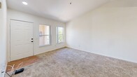 Located at 1701 N Jones Blvd in Las Vegas, NV, this two-bedroom, one-bathroom unit offers a well-organized single-level floor plan designed for comfortable everyday living. The combined kitchen and living room serves as the heart of the home, featuring vaulted ceilings with a ceiling fan, a skylight that draws in natural light, and warm wood-look flooring. The kitchen is equipped with oak-toned cabinetry offering ample storage, white appliances including a gas range, dishwasher, and refrigerator, along with a double sink and light countertops. The living area flows seamlessly from the kitchen and features plush carpeting, a front entry door, and windows that provide views of the surrounding landscape. Both bedrooms are carpeted and filled with natural light courtesy of large windows — the primary bedroom benefits from dual windows offering pleasant outdoor views, while the secondary bedroom is a quiet, versatile space. A connecting hallway leads to the full bathroom, which features a tub and shower combination with a curtain rod, a wood-vanity with overhead cabinetry, wood-look flooring, and clean white walls. The overall aesthetic is bright and neutral throughout, creating a move-in-ready canvas.