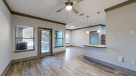 Located at 4651 S Custer Rd in McKinney, TX, this well-appointed one-bedroom, one-bathroom unit offers a thoughtfully designed single-floor layout. The open-concept living, dining, and kitchen area serves as the heart of the home, featuring wood-style flooring, crown molding, and a ceiling fan that enhances the bright, airy atmosphere. Multiple windows invite natural light throughout the main living space, which also provides direct access to a private patio.

The kitchen is equipped with stainless steel appliances — including a refrigerator, range, and microwave — complemented by rich dark cabinetry, granite countertops, a subway tile backsplash, and a peninsula with pendant lighting that doubles as a dining area. A pantry and dedicated utility room add practical storage and functionality.

The bedroom features plush carpeting, a ceiling fan, and a generous window. Three closets provide ample storage, including a walk-in closet accessible through the bathroom. The bathroom includes a soaking tub with subway tile surround and wood-style flooring. A dedicated laundry area and additional utility space round out this efficiently organized and comfortable home.