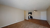 Located at 370 N Murray Blvd in Colorado Springs, Colorado, this single-floor residence offers a practical and comfortable layout designed for everyday living. The open-concept living and dining area features a combination of plush carpeting and durable wood-look flooring, with a ceiling fan overhead and a large sliding window that invites natural light and outdoor views. The textured ceilings are consistent throughout, adding a classic touch to the interior. The kitchen flows directly from the living area and is outfitted with bold dark cabinetry, a mosaic tile backsplash, white appliances including a range and refrigerator, and a ceiling-mounted light fixture — providing a functional and visually striking contrast. The bedrooms are carpeted and generously proportioned, each featuring baseboard heating units and windows that bring in natural light, creating a bright and comfortable atmosphere. One bedroom also includes a ceiling fan for added comfort. The bathroom is well-appointed with a full tub-and-shower surround in white, complemented by chrome fixtures and a safety grab bar. Warm neutral tones throughout the unit create a cohesive and welcoming ambiance, making this Colorado Springs residence a practical and move-in-ready home.