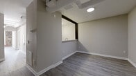 Located at 1420 Hull St in Richmond, Virginia's Hull Street corridor, this 2-bedroom, 2-bathroom unit blends industrial character with modern finishes. The open-concept living, dining, and kitchen area serves as the heart of the home, featuring light wood-style flooring, neutral gray walls, and a distinctive pass-through kitchen window that connects the living space to the kitchen. The kitchen is outfitted with white cabinetry and a built-in microwave, complemented by a dedicated pantry for additional storage. Exposed ductwork on the ceiling adds an industrial loft aesthetic to the common areas. Both bedrooms offer comfortable proportions, light wood-style flooring, and ample closet space. A standout feature of the bedrooms is the exposed brick accent wall surrounding large windows, lending warmth and historic character to the space while allowing natural light to filter in. The primary bedroom includes direct access to one of the two full bathrooms, each equipped with a full tub-shower combination. Additional conveniences include a dedicated laundry area, multiple closets throughout, and a hallway connecting the main living spaces. The overall design balances clean, contemporary finishes with the building's original architectural character.