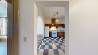 Located at 1234 S King St in Seattle's Judkins Park neighborhood, this one-bedroom, one-bathroom unit offers a well-organized single-floor layout with a comfortable sense of space throughout. Warm hardwood flooring runs consistently through the living room, dining room, bedroom, and hallways, lending a cohesive and inviting feel to the entire unit.

The living room is generously sized and benefits from natural light, while the adjacent dining room features distinctive wainscoting along the lower walls and a window overlooking the surroundings — a charming architectural detail that adds character to the space. The bedroom is a well-proportioned retreat with large windows that invite ample daylight and provide views of the neighborhood.

The kitchen is equipped with rich wood cabinetry, granite-style countertops, a stainless steel sink, and classic checkered tile flooring, offering a practical and visually distinct cooking space. The bathroom continues the warm wood flooring and includes a full soaking tub and shower combination, a vanity with stone-patterned countertops, and clean white walls.

Paneled doors and tall baseboards throughout the unit reflect thoughtful, classic architectural detailing. Two hallways connect the rooms efficiently, contributing to the unit's smooth and logical flow.