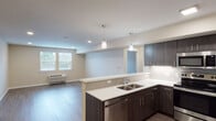 Located at 2220 SW 192nd Ave in Vancouver, Washington, this thoughtfully designed single-floor residence offers a clean, contemporary aesthetic throughout. The open-concept layout seamlessly connects the kitchen and living area, creating a bright and functional living space. The kitchen is a standout feature, equipped with stainless steel appliances including a range, over-the-range microwave, dishwasher, and refrigerator. Dark espresso-toned cabinetry provides generous storage, complemented by sleek white countertops and a subway tile backsplash. Pendant lighting over the peninsula adds a stylish finishing touch. The living area features wood-style plank flooring and windows that invite natural light, with a wall-mounted HVAC unit ensuring year-round comfort. A dedicated bedroom is finished with plush carpeting, a window with exterior views, and a flush-mount ceiling fixture, offering a cozy and quiet retreat. The bathroom includes a full tub and shower combination, wood-style flooring, and warm neutral wall tones. Recessed lighting and a consistent neutral color palette throughout the unit contribute to an overall atmosphere that is modern, clean, and move-in ready.