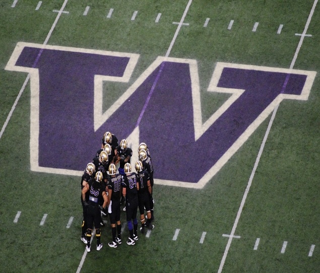 The Huskies huddle on the football field