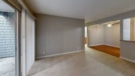 Located at 155 Stony Point Rd in Santa Rosa, CA, this one-bedroom, one-bathroom unit offers a practical and comfortable single-floor layout. The open-concept living, dining, and kitchen area forms the heart of the home, with plush wall-to-wall carpeting in the living and dining zones and warm hardwood flooring in the kitchen and dining transition area. A ceiling fan overhead and a sliding glass door leading to an outdoor balcony fill the living space with natural light and provide pleasant outdoor views of surrounding trees. The galley-style kitchen is well-equipped, featuring rich cherry wood cabinetry with glass-panel accents, granite countertops, a stainless steel sink, and matching appliances including an electric range and refrigerator. The bedroom offers a cozy carpeted retreat with a window for natural light and baseboard heating, and opens conveniently to the main living area. Two dedicated closets provide generous storage throughout the unit. The full bathroom includes a clean, white tub-shower combination with chrome fixtures. Textured ceilings throughout and neutral gray tones on the walls lend a cohesive, understated aesthetic across the entire space.