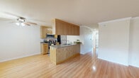Located in Castro Valley, CA, this well-appointed two-bedroom, one-bathroom residence offers a thoughtfully designed single-floor layout. The open-concept kitchen and living area serves as the heart of the home, featuring warm honey-toned cabinetry, granite countertops, and stainless steel appliances including a range, microwave, and refrigerator. A peninsula with a built-in sink adds functional prep space while connecting seamlessly to the living area, which is finished with light hardwood flooring, crown molding, and a ceiling fan. Sliding glass doors in the living room flood the space with natural light and provide outdoor access. Both bedrooms are carpeted and accented with crown molding, offering a comfortable and quiet retreat. The primary bedroom includes mirrored sliding closet doors that enhance the sense of space, along with a sliding door providing views of the outdoors. The second bedroom features a window with vertical blinds for adjustable light. The full bathroom is finished with tile flooring, a wood-toned vanity, and a well-lit mirror. Throughout, neutral warm tones and clean architectural details create a cohesive and inviting ambiance.