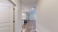 Located at 6805 Walnut Branch Ln in Charlotte, NC, this well-designed 2-bedroom, 2-bathroom single-floor residence offers a thoughtfully planned layout with modern finishes throughout. A welcoming entrance hall leads into an open-concept living area where the dining room, kitchen, and living room flow seamlessly together. The kitchen is a standout feature, showcasing light wood cabinetry, stone countertops, a large center island with bar seating, stainless steel appliances, and elegant pendant lighting overhead. Hardwood-style flooring runs throughout the main living areas, complemented by ceiling fans and abundant natural light. The living room offers access to a private balcony with metal railing, overlooking the exterior of the building. Both bedrooms are carpeted and include ceiling fans and natural light from windows, with the primary bedroom providing direct access to a spacious walk-in closet with built-in shelving and hanging rods. The bathrooms are finished with light tile flooring, wood-toned vanity cabinetry, stone countertops, and a combined tub and shower. A dedicated laundry room with full-size washer and dryer hookups adds everyday convenience. The overall aesthetic is clean, neutral, and move-in ready.