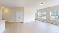 This single-floor residence at 9800 Shore Break Ln in Berlin, Maryland offers a clean, modern design throughout. Light wood-style flooring flows seamlessly across all areas, complementing the warm neutral wall tones and crisp white trim that define the overall aesthetic. The open-concept living and dining area is generously proportioned, benefiting from multiple large windows that invite abundant natural light and offer views of the surrounding greenery. A full-length sliding glass door connects the main living space to the outdoors, enhancing the sense of openness. The kitchen is well-appointed with light wood-tone cabinetry extending to the ceiling, stainless steel appliances including a refrigerator, electric range, and microwave, and elegant stone-look countertops with an island that provides additional prep and storage space. The bedrooms are comfortably sized, with multiple windows for natural light and closet access — the primary bedroom features a spacious walk-in closet alongside an additional secondary closet. The bathroom includes a full soaking tub with shower, toilet, and consistent flooring throughout. With its bright, airy atmosphere and functional layout, this residence provides a comfortable and contemporary living environment in Berlin, MD.