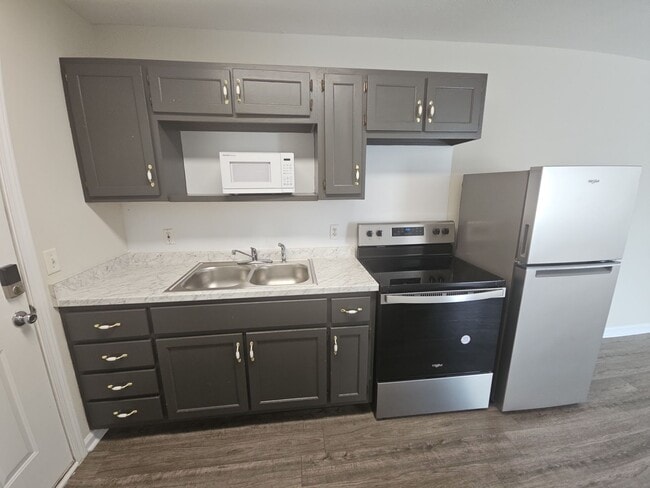 a full size refrigerator, electric stove, and ample cabinet storage. - 1351 N Dixie Ave