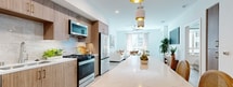 This contemporary 1120 square foot apartment in San Diego offers a harmonious blend of style and functionality. The open-concept design seamlessly integrates the living room, dining area, and kitchen, creating a spacious and airy atmosphere. The kitchen boasts modern appliances, light wood cabinetry, and a large island with seating, perfect for casual dining or entertaining.

Both bedrooms are generously sized, with the primary bedroom spanning 210 square feet. Large windows in the bedrooms and living areas flood the space with natural light, while modern ceiling fans ensure comfort. The bathrooms feature sleek fixtures, including a bathtub in one and ample storage space.

Throughout the apartment, neutral tones dominate, accented by pops of color in the decor. Light wood flooring unifies the space, complementing the overall modern aesthetic. Thoughtful details like built-in closets, modern light fixtures, and carefully chosen artwork contribute to the apartment's polished look.

The floor plan is efficiently designed, with two hallways and two closets providing additional storage options. The living spaces are adorned with contemporary furniture and decor, creating a welcoming and stylish ambiance. This well-appointed apartment offers a perfect balance of comfort and sophistication in its 1120 square feet of living space.