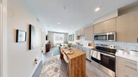 Located at 1639 E Tropicana Ave in Las Vegas, NV, this well-designed one-bedroom, one-bathroom unit offers a smart, functional layout across a single floor. The open-concept kitchen and living area form the heart of the space, where light-toned cabinetry, a white subway tile backsplash, dark countertops, and a full suite of stainless steel appliances — including a French door refrigerator with ice maker, electric range, microwave, and dishwasher — create a contemporary and practical kitchen. A freestanding wood-top island provides additional prep and dining space. Wood-style flooring runs throughout, adding warmth and visual continuity. The living area is bright and welcoming, benefiting from large windows that invite natural light and offer outdoor views. The bedroom is a comfortable retreat featuring a large sliding window, ceiling fan, and ample natural light. The full bathroom is clean and efficiently designed. A dedicated in-unit laundry area houses a stacked full-size washer and dryer, a convenient feature rarely found in similarly sized units. Recessed lighting and neutral wall tones throughout give the space a modern, cohesive aesthetic well-suited to everyday Las Vegas living.