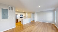 Located at Preserve Crossing in Gahanna, Ohio, this well-designed one-bedroom, one-bathroom unit offers a clean, modern aesthetic throughout. The open-concept layout seamlessly connects the kitchen and living area, creating a bright and functional shared space. Light hardwood flooring flows through the main living areas, contributing to the home's airy feel.

The kitchen is a standout feature, equipped with crisp white shaker cabinetry, light countertops, a white tile backsplash, and a full suite of stainless steel appliances including a refrigerator, electric range, and over-the-range microwave. A peninsula with an integrated sink adds prep space and separates the kitchen from the open living area.

The living room benefits from natural light through windows dressed with horizontal blinds, offering a calm and neutral backdrop. The bedroom is carpeted for comfort and includes a window that brings in natural light. It connects directly to a dedicated walk-in closet outfitted with wire shelving and additional hanging space, providing practical storage.

The bathroom continues the home's consistent neutral palette, featuring hardwood-style flooring, a white vanity with light countertops, and clean, simple finishes throughout. The unit's cohesive design, modern fixtures, and efficient use of space make it a practical and comfortable residence.