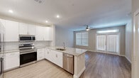 Located at 3880 FM 2920 in Spring, TX, this one-bedroom, one-bathroom unit offers a well-designed single-floor layout with modern finishes throughout. The open-concept kitchen and living area serves as the heart of the home, featuring crisp white shaker cabinets, a classic subway tile backsplash, granite countertops, and a central island with a built-in sink — ideal for both cooking and casual dining. A full suite of stainless steel appliances includes a refrigerator, electric range, microwave, and dishwasher. Light wood-look flooring flows throughout the main living areas, complementing the neutral, warm-toned walls. The living room is bright and airy, benefiting from natural light through large windows and a glass-paneled door with a transom window above. A ceiling fan adds comfort to the space. The bedroom is carpeted and well-sized, offering a ceiling fan and a window with blinds. The bathroom features granite countertops, white cabinetry, and wood-look flooring, with direct access to a dedicated walk-in closet complete with a clothing rod and carpeted flooring. The overall aesthetic is clean, contemporary, and move-in ready.