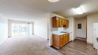 Located at 1400 Coconino Rd in Ames, Iowa, this single-floor unit offers four bedrooms and one bathroom within a efficiently arranged floor plan. The open-concept kitchen and living area serves as the heart of the space, where warm honey-toned wood cabinetry lines both sides of a galley-style kitchen equipped with white appliances, including an electric range and dishwasher, set atop durable hardwood-style flooring. A pendant light fixture adds a functional accent above the kitchen. The kitchen flows seamlessly into the carpeted living room, which is bathed in natural light and features a sliding glass door that opens to an outdoor balcony with neighborhood views. The four bedrooms are each carpeted and feature neutral walls, textured ceilings, and windows that bring in natural light with views of the surrounding community. The single full bathroom is finished with hardwood-style flooring, a wood-toned vanity with a white countertop, a lighted mirror, and a tub/shower combination with a sliding glass door. A hallway connects the bedroom wing to the main living areas, keeping the layout organized and functional. Throughout the unit, textured ceilings and clean, neutral finishes create a cohesive and practical living environment.