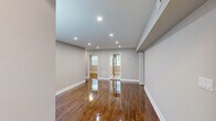 Located at Barrett Drive in Kendall Park, NJ, this well-appointed two-bedroom, one-bathroom single-floor home offers a thoughtfully designed layout with consistent, high-quality finishes throughout. Rich, polished hardwood floors flow seamlessly across the living areas and bedrooms, lending warmth and character to the space.

The living room is a generous, open area illuminated by recessed lighting, with neutral gray walls and large windows fitted with blinds that allow for ample natural light. The kitchen is outfitted with dark shaker-style cabinetry, white quartz countertops, a subway tile backsplash, and a full suite of stainless steel appliances including a gas range, built-in microwave, dishwasher, and refrigerator. Light-toned tile flooring completes the kitchen's clean, modern aesthetic.

The spacious primary bedroom features hardwood flooring, a built-in closet with bifold doors, and a window providing natural light. The second bedroom is similarly finished with hardwood floors and a window overlooking the outdoors. The bathroom is elegantly appointed with floor-to-ceiling marble-style tile surrounding the tub and shower, a dark-finished vanity with a white countertop, and large-format floor tiles. The home also includes a dedicated entrance, hallway, and closet for added functionality.