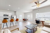 Located at 10 Bridgestone Ave in Conyers, GA, this well-appointed two-story home offers a thoughtfully designed layout across two floors. The main level features a bright, open-concept living, dining, and kitchen area bathed in natural light from multiple windows. The kitchen is outfitted with crisp white cabinetry, granite countertops, stainless steel appliances including a French door refrigerator and range, and a central island with bar seating. Light hardwood-style flooring flows throughout the main level, complemented by recessed lighting and ceiling fans. A clean hallway connects the entry to the living space, with a staircase leading to the upper floor. The attached garage provides ample storage and parking space with an automatic opener. Upstairs, the spacious primary bedroom features plush carpeting, a ceiling fan, and access to a closet. The secondary bedroom is bright and airy, with hardwood-style flooring and a window with outdoor views. Three well-finished bathrooms feature granite vanities and white cabinetry. A dedicated laundry room with washer and dryer and a pantry add practical convenience. With four closets and a neutral color palette throughout, this home offers comfort, functionality, and a clean, modern aesthetic.
