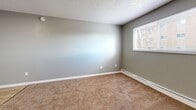 Located at 2634 E Yampa St in Colorado Springs, Colorado, this one-bedroom, one-bathroom unit offers a compact and efficient single-floor layout designed to maximize functionality. The space is finished with neutral gray walls throughout, textured ceilings, and a combination of light wood-look vinyl flooring in the main areas and plush wall-to-wall carpeting in the bedroom and living spaces.

The bedroom is a well-proportioned room featuring a baseboard heating unit, a wide window that brings in natural light and frames views of surrounding trees, and direct access to the hallway and closets. Two closets provide ample storage for the space.

The bathroom includes a full tub-and-shower combination lined with clean white square tile, framed by a classic paneled door with brushed nickel hardware.

The kitchen connects to a dedicated pantry, offering practical storage solutions. A hallway links all rooms cohesively, contributing to the efficient flow of the unit. The overall ambiance is clean, neutral, and move-in ready, with consistent finishes throughout that create a unified and low-maintenance living environment. This unit is well-suited for those seeking a manageable, easy-to-navigate space in Colorado Springs.