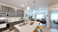 This single-story residence in Gulf Breeze, Florida, offers a thoughtfully designed open-concept floor plan that maximizes functionality and flow. The kitchen serves as the heart of the home, featuring dark espresso cabinetry extending to the ceiling, stainless steel appliances including a refrigerator, electric range, and microwave, and crisp quartz countertops. A central island with an undermount sink and seating for two is highlighted by stylish pendant lighting, making it an ideal spot for casual dining or entertaining. Light wood-style flooring runs throughout the main living areas, creating a warm, cohesive aesthetic.

The living room is generously proportioned, filled with natural light from large windows dressed in sheer curtains, and is equipped with a ceiling fan. The bedroom offers plush carpeting, a ceiling fan, ample natural light, and access to a dedicated walk-in closet with built-in shelving. The bathroom is clean and bright, featuring wood-tone cabinetry, a quartz vanity, and a tub-shower combination. A dedicated in-unit laundry area accommodates a full-size washer and dryer, adding everyday convenience to this well-rounded residence.