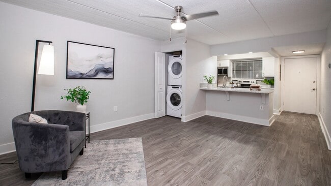Floor plans feature open-concept living areas featuring stylish wood-style flooring, a ceiling fan, and a convenient in-unit washer and dryer. - POSTE Winter Park Apartments