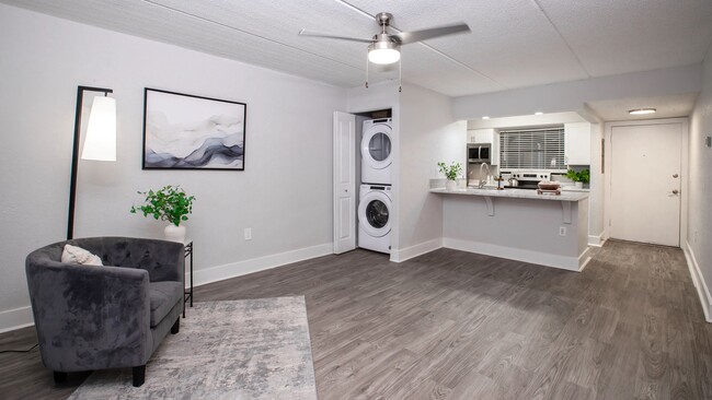 Floor plans feature open-concept living areas featuring stylish wood-style flooring, a ceiling fan, and a convenient in-unit washer and dryer. - POSTE Winter Park