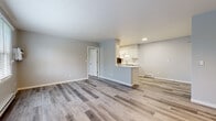 Located at 120 Meadowlands Dr in Chardon, Ohio, this freshly updated single-floor unit offers a clean, modern aesthetic throughout. The open-concept living and dining area is expansive and bright, finished with light gray luxury vinyl plank flooring that flows seamlessly through the space. Neutral gray walls and white trim create a crisp, contemporary atmosphere.

The kitchen is well-appointed with white shaker-style cabinetry, white quartz countertops, and a full suite of stainless steel appliances including a range, microwave, dishwasher, and refrigerator. A peninsula with seating overhang connects the kitchen to the living space, and a stacked washer and dryer unit is conveniently integrated within the kitchen area.

The bedroom is generously sized with a ceiling fan, a window with blinds allowing natural light, and baseboard heating. An adjacent room provides access to both the full bathroom and a walk-in closet. The bathroom features marble-look tile flooring, a white vanity with quartz countertop, and a full tub-shower combination. Additional storage is provided by a utility closet with wire shelving and a water heater. Throughout the unit, the design is cohesive, clean, and move-in ready.
