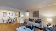 This single-floor residence is thoughtfully laid out to maximize comfort and functionality across its main living spaces. The living room serves as the central hub of the home, featuring warm hardwood flooring, a textured ceiling, and neutral walls that provide a versatile backdrop. A sliding glass door fills the space with natural light and opens directly to a private patio, offering a seamless indoor-outdoor connection. The kitchen is efficiently designed with natural wood cabinetry, a white appliances package including a refrigerator and dishwasher, a double sink, and light countertops. It connects openly to a dedicated dining area, creating a practical flow for everyday living. Two bedrooms are carpeted for comfort and each feature windows that invite natural light and outdoor views. The rooms offer generous wall space suitable for various furniture arrangements. The bathroom is clean and straightforward, equipped with a combined tub and shower enclosure and light wood-look flooring. Throughout the residence, the consistent use of warm tones and practical finishes contributes to a cohesive, welcoming atmosphere.