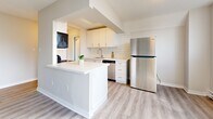 Located at 125 Wellington Street North in Hamilton, Ontario, this one-bedroom, one-bathroom unit offers a thoughtfully designed layout across a single floor. Light-toned luxury vinyl plank flooring runs throughout the space, complementing the bright, neutral colour palette that enhances the sense of openness.

The galley-style kitchen is a standout feature, outfitted with crisp white cabinetry, white subway tile backsplash, quartz countertops, a stainless steel sink, and a full suite of appliances including a stainless steel refrigerator, electric range with over-the-range microwave, and dishwasher. A peninsula counter connects the kitchen to the combined living and dining area, creating an open, functional flow.

The living and dining area is spacious and bright, benefiting from large sliding glass doors that lead to a private balcony offering city views. The bedroom is a comfortable size, featuring a closet with sliding doors, a large window with outdoor views, and direct access to the bathroom.

The bathroom is finished with classic white subway tile surrounding the tub/shower combo, complemented by light wood-toned flooring. Additional storage is provided by two closets. The unit also includes a dedicated entrance and baseboard heating throughout.