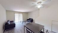 This two-story apartment offers 1,090 square feet of functional living space across two floors, accommodating three bedrooms and three full bathrooms. The ground floor (590 sq ft) features an open-concept kitchen and living area anchored by durable wood-look vinyl flooring throughout. The kitchen is equipped with white cabinetry, laminate countertops, a double-basin sink, electric range, dishwasher, and a full-size refrigerator, complemented by a pass-through counter opening to the dining area. The living room benefits from abundant natural light via sliding glass doors fitted with vertical blinds, providing direct access to an outdoor patio. A dedicated laundry room on this floor houses a full-size side-by-side washer and dryer. The upper floor (510 sq ft) hosts the three bedrooms, connected by hallways and served by the remaining bathrooms. The primary bedroom measures 160 sq ft and features a ceiling fan, built-in closet with shelving, and a sliding glass door. Additional bedrooms include closets and ceiling-mounted light fixtures. Bedrooms on the upper floor are finished with plush carpeting. All three bathrooms are consistently appointed with tub/shower combos, wood-look vinyl flooring, and vanities with granite-style countertops.