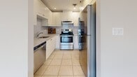 Located on Boulevard Cavendish in Montréal, this well-appointed 3-bedroom, 2-bathroom unit offers a generous and thoughtfully laid-out living space across a single floor. The entry hallway, finished with light ceramic tile, leads seamlessly into an expansive living and dining area bathed in natural light from large floor-to-ceiling windows and a sliding glass door opening to a balcony. This bright main area features warm hardwood flooring and panoramic views of the surrounding cityscape, enhanced by an elegant pendant light fixture. The kitchen is efficiently designed with white cabinetry, granite countertops, a subway tile backsplash, and stainless steel appliances including a range, refrigerator, and dishwasher. The generously sized primary bedroom enjoys dual windows framing elevated city views, while the two additional bedrooms also feature hardwood flooring and ample closet space. Both bathrooms are finished with ceramic tile flooring and white vanities topped with granite countertops; one includes a shower-tub combination. A dedicated in-unit laundry room accommodates a full-sized washer and dryer alongside a water heater. The unit's neutral palette, consistent finishes, and abundant natural light throughout create a bright, functional, and welcoming living environment.